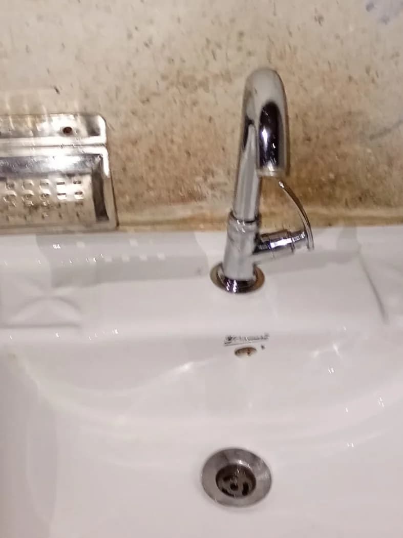 Shining tap and clean white washbasin after using TapStrike Intense